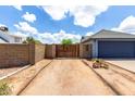 View of the driveway, two-car garage, privacy gate, and xeriscaped front yard, perfect for curb appeal at 161 S Maple St, Chandler, AZ 85226