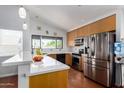 Bright kitchen features stainless steel appliances, light wood cabinets and a breakfast bar at 161 S Maple St, Chandler, AZ 85226