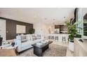 Inviting living room with white sofa, modern decor, and seamless flow to the kitchen at 17345 W Smoketree Dr, Surprise, AZ 85387