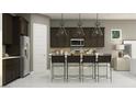 Gourmet kitchen with dark cabinets, stainless steel appliances, and a large island at 17403 W Swayback Pass, Surprise, AZ 85387