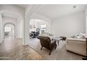 Bright living room features neutral colors, plush seating and elegant arches to dining area at 19242 W Pasadena Ave, Litchfield Park, AZ 85340