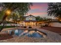 Backyard pool and patio with outdoor lighting create a relaxing evening ambiance at 20412 W Thayer St, Buckeye, AZ 85396