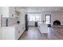 Open kitchen with updated appliances, white cabinetry, and granite countertops at 2309 W Naranja Ave, Mesa, AZ 85202