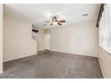 Spacious carpeted living room with a ceiling fan and a view to the stairs at 4380 E Renee Dr, Phoenix, AZ 85050