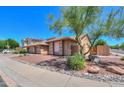 A tan home exterior features desert landscaping with gravel and plants under a blue sky at 4560 E Paso Trl, Phoenix, AZ 85050