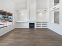 Bright living room offers natural light, vaulted ceilings, cozy fireplace and laminate flooring at 5501 W Whispering Wind Dr, Glendale, AZ 85310