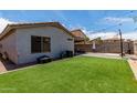 Private backyard with a well-maintained lawn, a covered patio, and a block wall for seclusion at 5526 W Ellis Dr, Laveen, AZ 85339