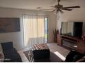 View of living room with sliding glass door to patio, ceiling fan, and tile flooring at 7118 S 37Th Gln, Phoenix, AZ 85041