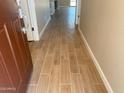 Hallway featuring light brown wood-look tile flooring throughout, and neutral tan wall paint at 7243 E Cattle Call St, San Tan Valley, AZ 85143