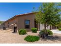 A low-maintenance yard surrounds this single-Gathering home with a window awning and plenty of greenery at 8012 S Magic Dr, Casa Grande, AZ 85193