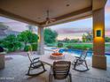 Inviting covered patio with fire pit and outdoor seating next to a sparkling pool at 9878 N 79Th Pl, Scottsdale, AZ 85258