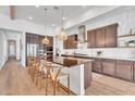 Open-concept kitchen with island seating, stainless steel appliances, custom cabinets, and stylish pendant lighting at 10006 E Rotation Dr, Mesa, AZ 85212