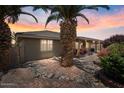 Charming backyard with lush landscaping, covered patio, and desert rock garden at 11025 E Nichols Ave, Mesa, AZ 85209