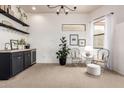 Bright sitting area with decorative shelving, sleek black bar, and modern chandelier at 12642 N Mountainside Dr # B, Fountain Hills, AZ 85268