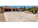 Large driveway leading to a two-car garage, showcasing ample parking and desert-friendly landscaping at 12837 N 68Th St, Scottsdale, AZ 85254