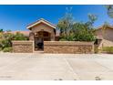 Inviting home featuring a stone-accented courtyard and a covered entrance, nestled behind desert landscaping at 12837 N 68Th St, Scottsdale, AZ 85254
