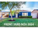 Charming blue home with green lawn, trimmed hedges, and a beautiful shade tree at 1622 N 17Th Ave, Phoenix, AZ 85007
