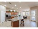 Well-equipped kitchen featuring an island with seating, stainless steel appliances, and wood cabinetry at 18226 W Stinson Dr, Surprise, AZ 85374