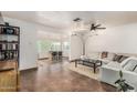 Bright living room featuring tile floors, a ceiling fan, and open access to the dining area at 2019 W Stella Ln, Phoenix, AZ 85015