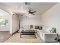 Spacious living room with comfortable seating, a ceiling fan, and a decorative floor lamp at 2019 W Stella Ln, Phoenix, AZ 85015