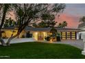 Charming single-story home with a lush green lawn and a stylish, modern garage door at 26 W Morten Ave, Phoenix, AZ 85021