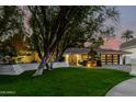 Charming single-story home with a lush green lawn and a stylish, modern garage door at 26 W Morten Ave, Phoenix, AZ 85021