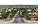 A beautiful aerial view of homes and a street with a palm tree in a desert neighborhood with mountain views at 2627 E Gary Way, Phoenix, AZ 85042