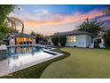 Expansive backyard featuring a sparkling pool, lounge area, and putting green for relaxation at 3429 E Coolidge St, Phoenix, AZ 85018