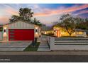 Charming home exterior with a bright red garage door, manicured lawn and vibrant landscaping at 3429 E Coolidge St, Phoenix, AZ 85018