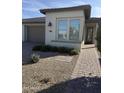 Charming home exterior with desert landscaping, paver walkway and two car garage at 36047 N Copper Hollow Way, Queen Creek, AZ 85140