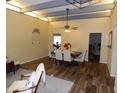 Spacious dining area with wood floors transitioning into carpet in the living room, and a ceiling fan at 3726 W Campo Bello Dr, Glendale, AZ 85308