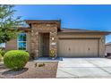 Beautiful single-story home featuring a stone-accented entrance and a two-car garage at 41825 W Mesquite Rd, Maricopa, AZ 85138