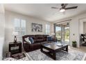 Spacious living room with a leather sofa, decorative rug, and natural light from the sliding glass doors at 41825 W Mesquite Rd, Maricopa, AZ 85138