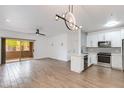 Open-concept living space with modern lighting, sliding glass door, and adjacent kitchen at 5401 E Van Buren St # 1004, Phoenix, AZ 85008