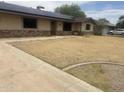 Charming single-story home featuring stone accents, desert landscaping, and modern solar panels at 5542 W Monte Cristo Ave, Glendale, AZ 85306
