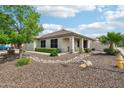 Inviting single-story home with manicured landscaping, desert rock, and a charming front porch at 6439 W Kristal Way, Glendale, AZ 85308