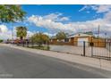 Quaint single-story home with a fenced yard, street view, and a glimpse of the neighborhood at 6837 W Camelback Rd, Phoenix, AZ 85033