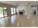 Bright living room with neutral tile flooring, a cozy fireplace, and access to an outdoor patio at 7272 E Gainey Ranch Rd # 122, Scottsdale, AZ 85258