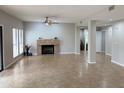 Spacious living room features neutral tile flooring, a fireplace, and ample natural light at 7272 E Gainey Ranch Rd # 122, Scottsdale, AZ 85258