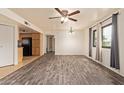 Inviting living room featuring wood floors, modern ceiling fan, neutral paint, and adjacent kitchen at 8155 E Roosevelt St # 205, Scottsdale, AZ 85257