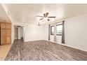 Bright living room featuring wood floors, modern ceiling fan, neutral paint, and window with grey curtains at 8155 E Roosevelt St # 205, Scottsdale, AZ 85257