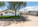 Well-maintained home with mature trees, a spacious driveway, and an attached carport providing convenience at 8315 E Devonshire Ave, Scottsdale, AZ 85251