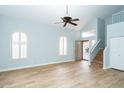 Bright living room with wood floors, vaulted ceiling, and large arched windows to fill the space with natural light at 909 W San Mateo Ct, Gilbert, AZ 85233