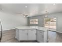 Kitchen island with quartz countertops and white cabinetry, overlooking the living area at 9224 W Raymond St, Tolleson, AZ 85353