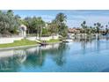Stunning waterfront view with lush greenery, mature palm trees, and a private dock at 10458 N 101St St, Scottsdale, AZ 85258