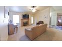 Cozy living room featuring a fireplace, comfortable seating, and ample natural light from the window at 1219 E Avenida Isabela --, Casa Grande, AZ 85122