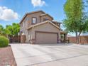 Charming two-story home featuring a two-car garage, landscaped front yard, and inviting covered porch at 14626 N 132Nd Ave, Surprise, AZ 85379