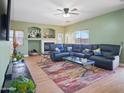 Spacious living room featuring plush seating, a fireplace, and ample natural light at 14626 N 132Nd Ave, Surprise, AZ 85379
