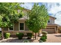 Charming home featuring a well-maintained yard with stone accents and a brick driveway at 14727 W Pasadena Ave, Litchfield Park, AZ 85340