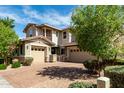 Beautiful home features a well-maintained yard with stone accents and brick driveway at 14727 W Pasadena Ave, Litchfield Park, AZ 85340